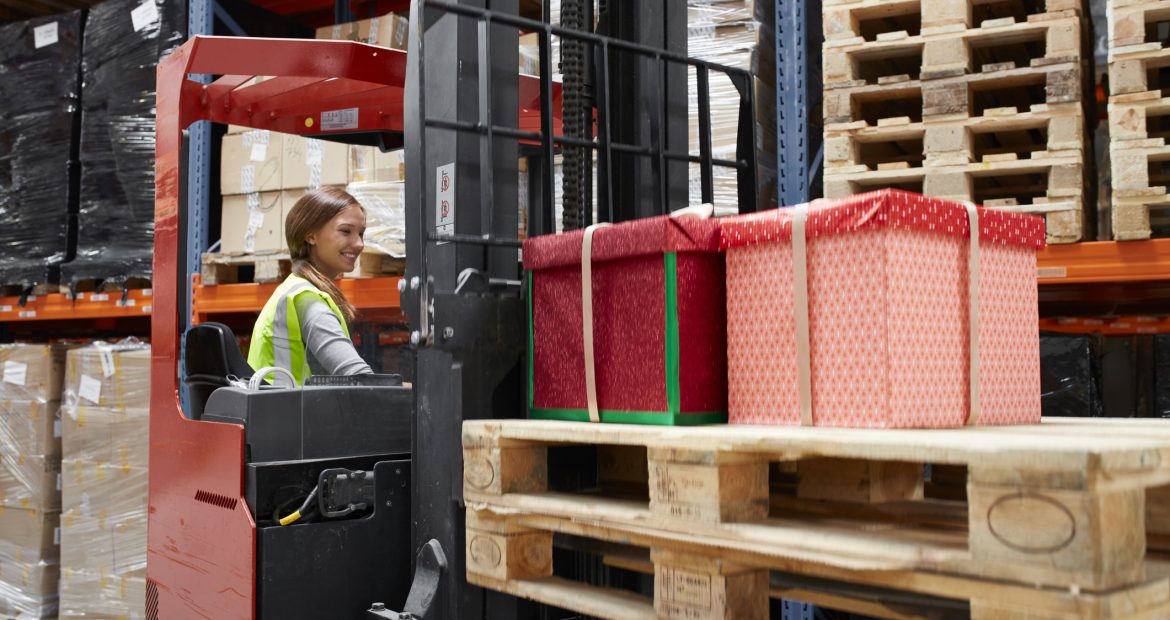 Woman moving parcels on a forklift